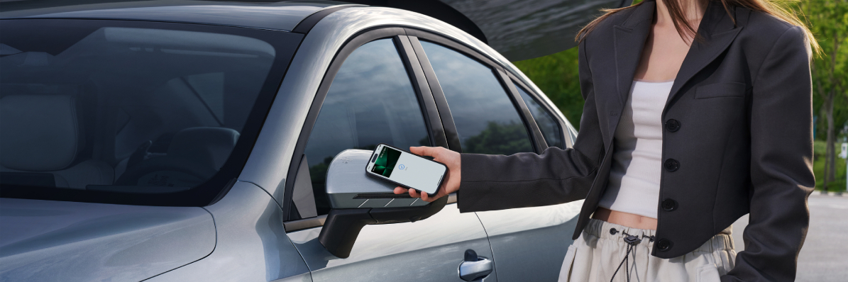 Osoba odemyká vůz BYD Seal 5 DM-i pomocí digitálního klíče v chytrém telefonu přes NFC v zrcátku